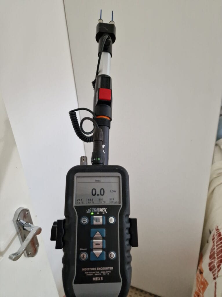 A moisture meter attached to a pole to take high readings.